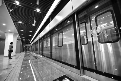 昨天，地铁6号线西延杨庄站站台内部装修已进入尾声，一辆在轨道试跑的列车在工作人员注视下离站。